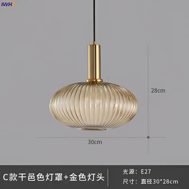 A sleek amber-tinted glass pendant light with vertical ridges and brass stem for modern dining room lighting