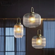 Three elegant decorbites clear glass pendant lamps with vertical ridges and brass accents for bedroom lighting