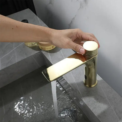 Modern ridged gold sensor mixer faucet with a sleek rectangular spout and textured cylindrical handle for bathroom sink