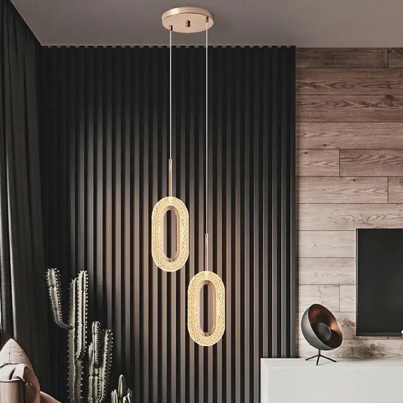 Two elegant oval-shaped modern rose gold acrylic led pendant lights with intricate mesh detailing for dining room chandelier