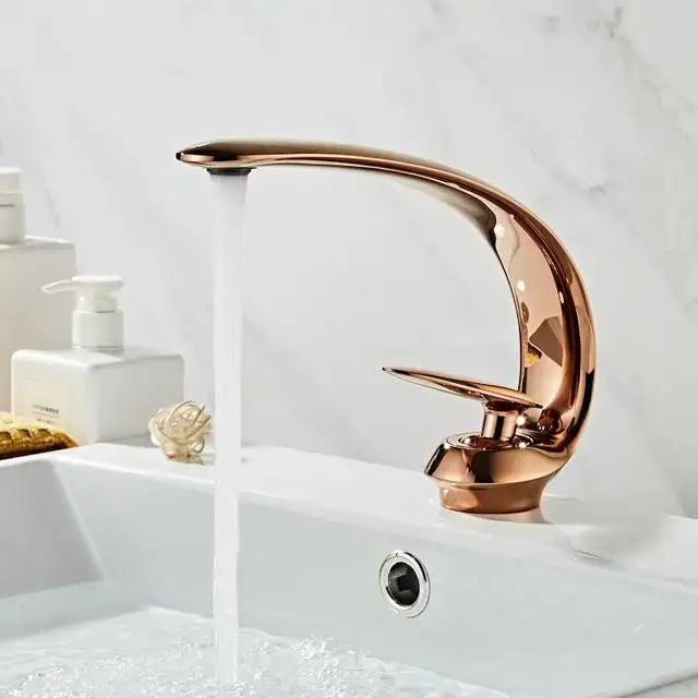 A modern rose gold basin faucet with curved design and polished black brass finish by decorbites basin faucet