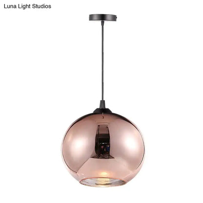 Modern rose gold copper sphere pendant light with a sleek mirrored glass globe and black metal hardware for kitchen bar