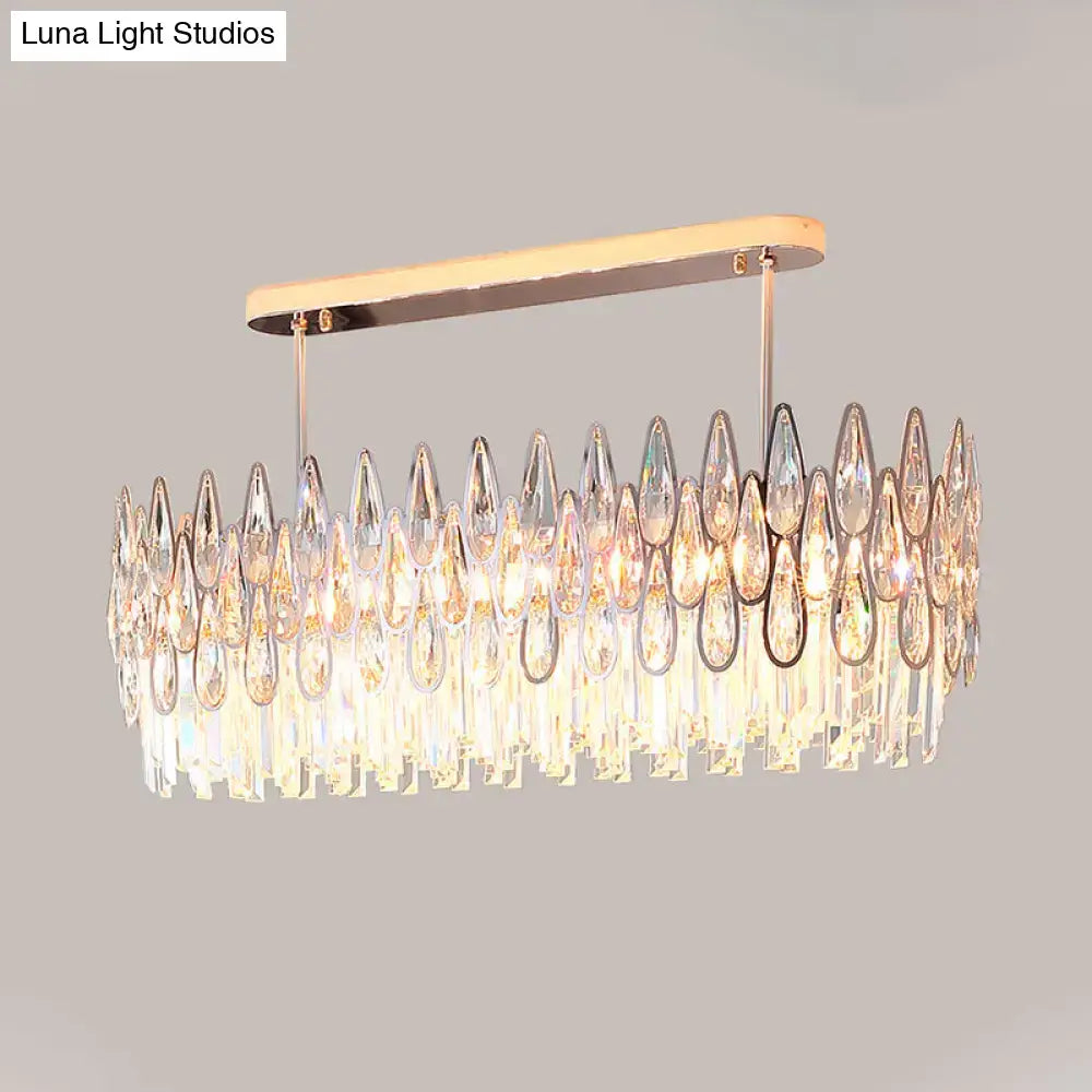 A modern rose gold island lighting chandelier with a rectangular metal frame and cascading crystal tiers for kitchens