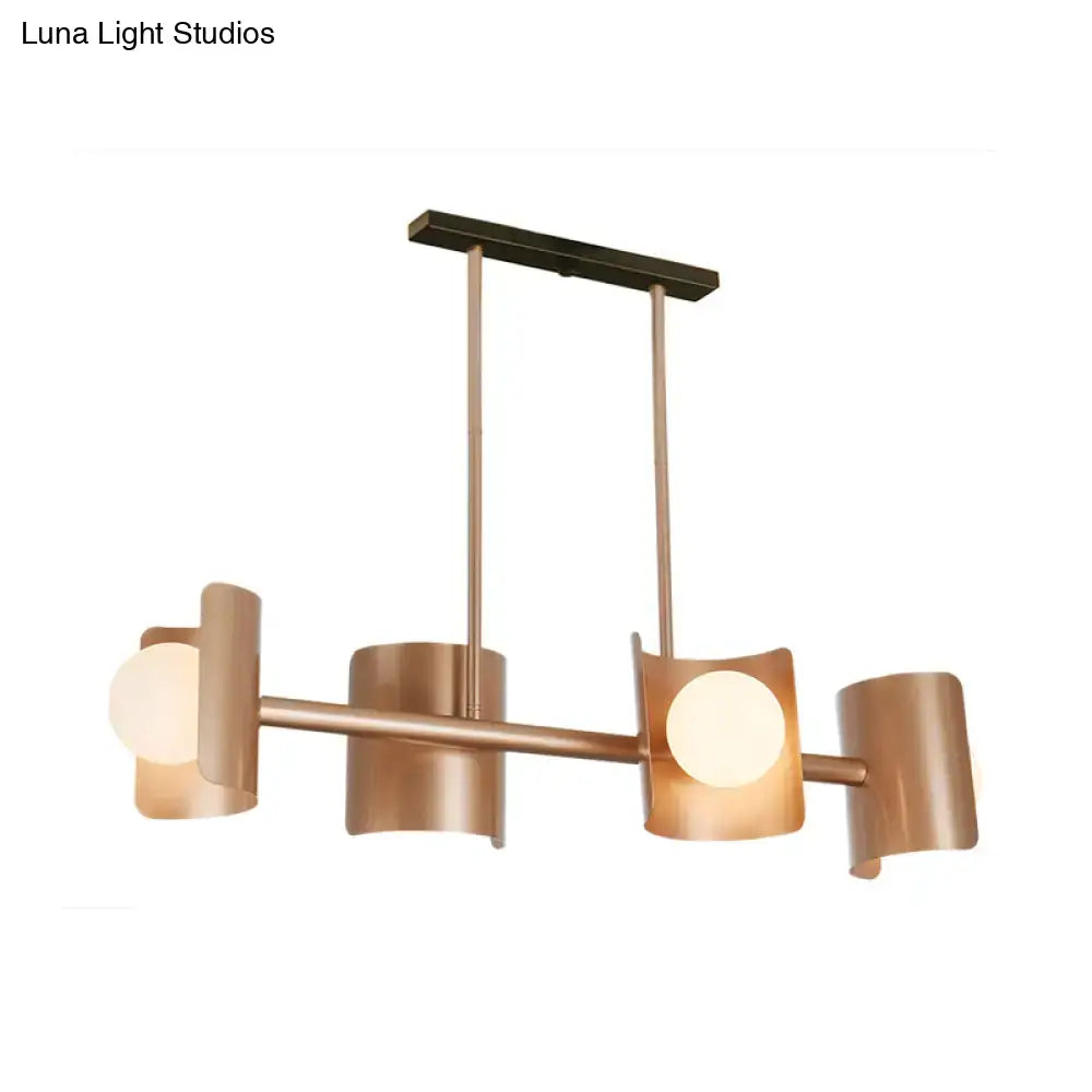 Modern rose gold pendant light with copper-toned cylindrical shades and warm glowing bulbs for dining room use