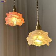 Two modern rose orange and creamy white glass led pendant lights with brass fixtures for kitchen use