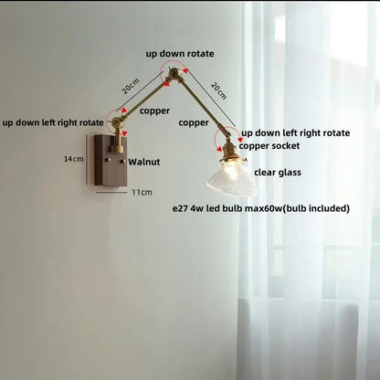 Adjustable copper wall light fixture with clear glass shade and walnut-finished mounting plate for modern interiors
