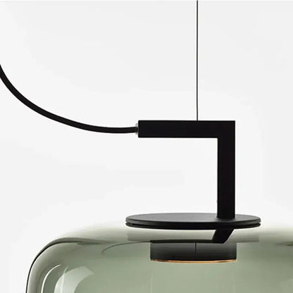 Black metal arm and base supporting a translucent olive green brokis glass pendant lamp for dining room decorbites brokis glass