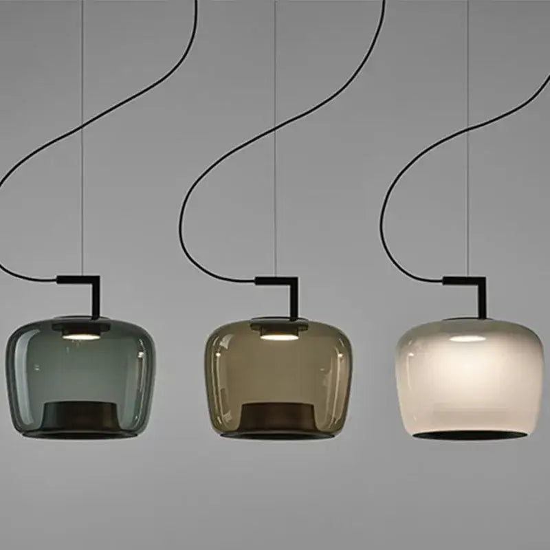 Modern sage green brokis glass pendant lamp with three curved black cords and muted green amber frosted shades for dining room decorbites brokis glass