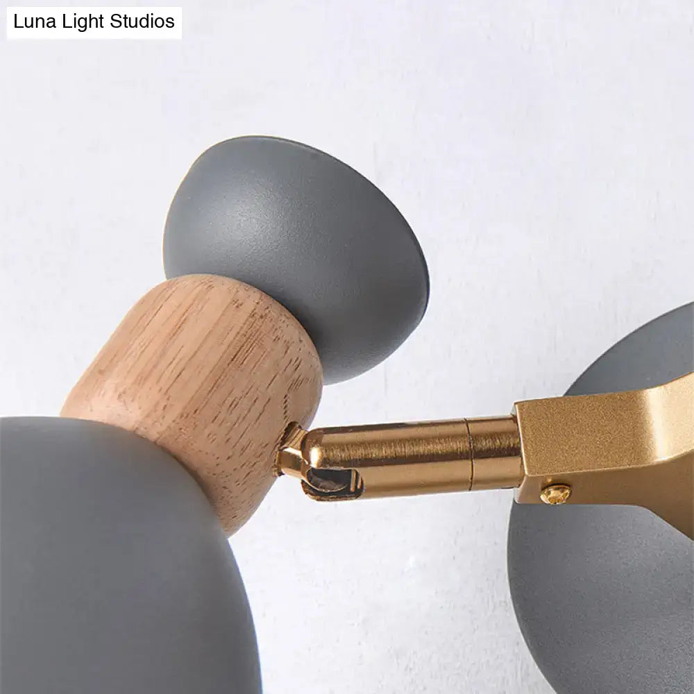 Modern sage green and gray double shade wall sconce with gray matte spherical shades on light wood and brass arm direct wired