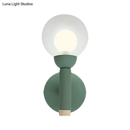 Modern sage green macaron style torch wall light with frosted glass globe and wooden accent for bedroom sconce