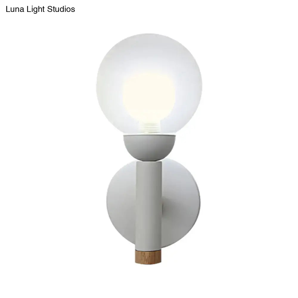 Minimalist wall light with frosted globe, matte grey white metal body, and natural wood detail in macaron style torch design