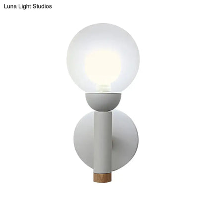 Minimalist wall light with frosted globe, matte grey white metal body, and natural wood detail in macaron style torch design