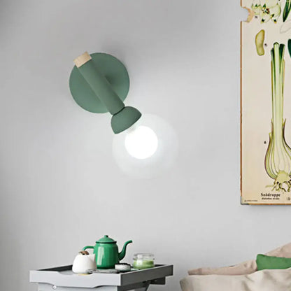 A sleek matte sage green macaron style torch wall light with wooden accent for modern bedroom sconce lighting