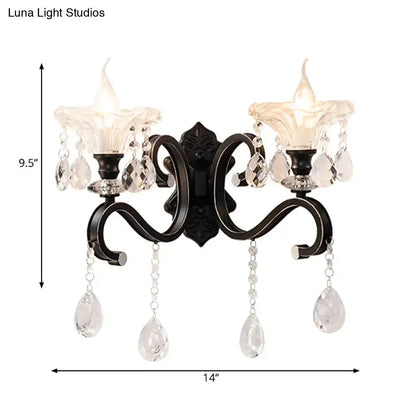 Modern scalloped black wrought iron wall lamp with curved arm, two candle glass shades, direct wired with crystal pendants