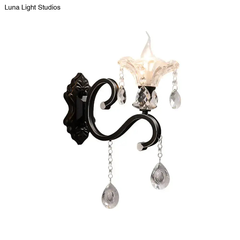Elegant black wrought iron wall lamp with curved arm direct wired featuring crystal teardrop pendants and faceted glass shade
