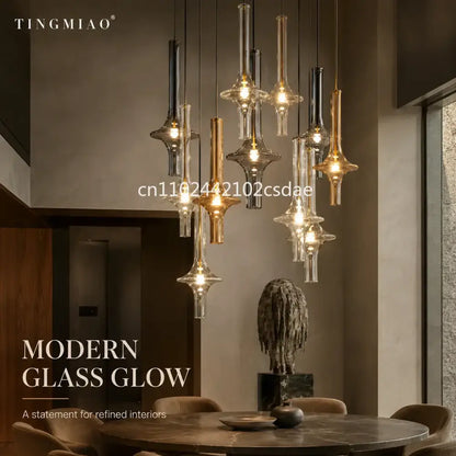 Modern sculptural glass pendant light featuring clear and amber hues with metallic accents for dining room use