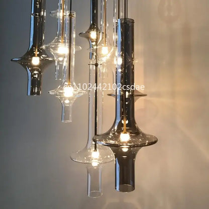 Modern sculptural glass pendant light featuring clear and smoked glass shades with sleek metallic fixtures for dining room