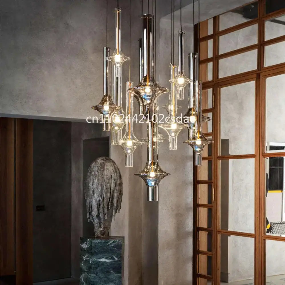Modern sculptural glass pendant light with metallic accents and warm glowing bulbs for dining room use