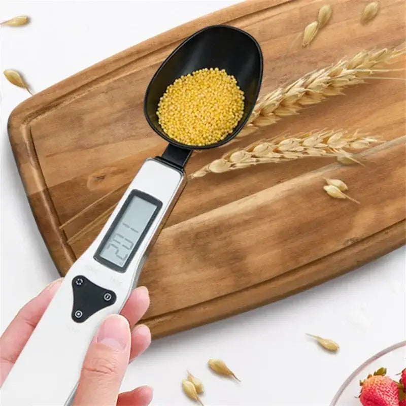 A sleek modern silver and black digital kitchen spoon scale displaying 20.1 grams of yellow millet by decorbites digital kitchen