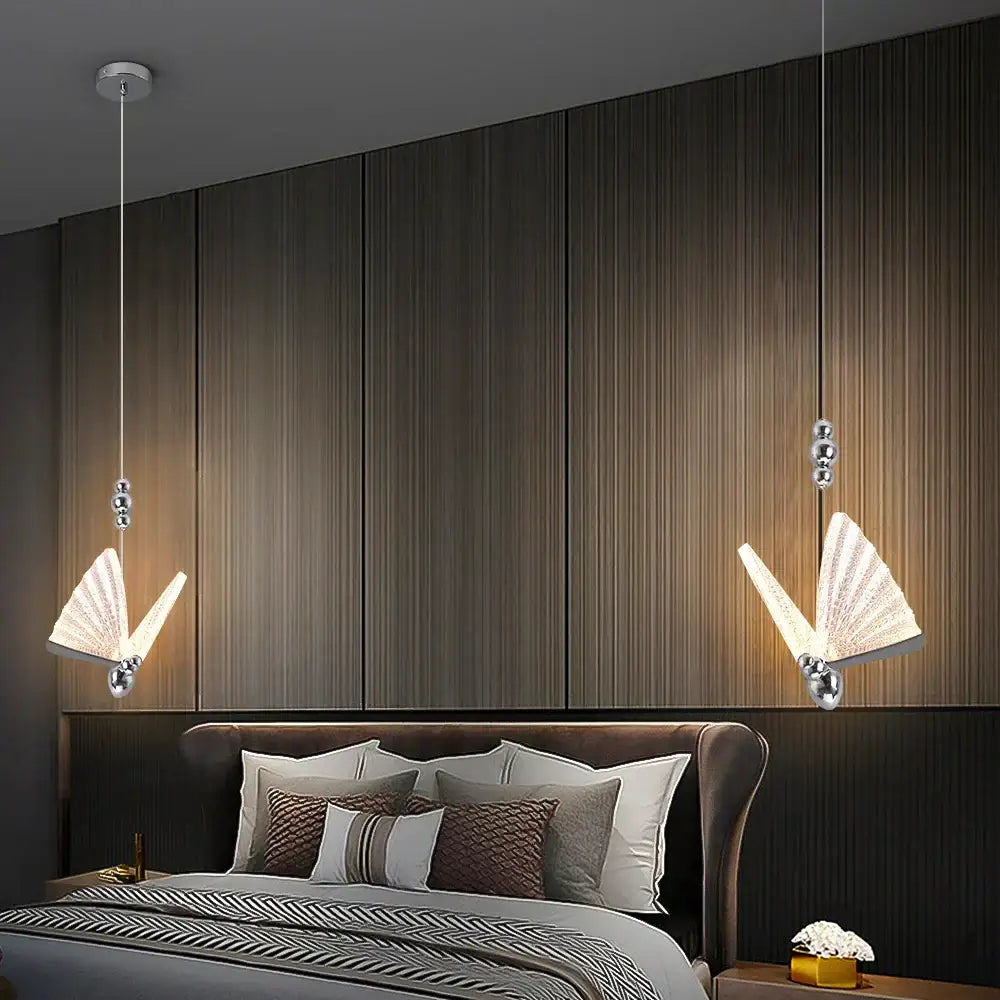 Two elegant silver butterfly led pendant lights with fan-shaped diffusers hang above a bed for modern decorbites decor