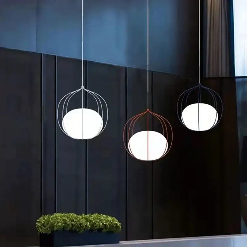Three modern pendant lights with white glass ball pendant shades in silver and copper birdcage frames for dining room use