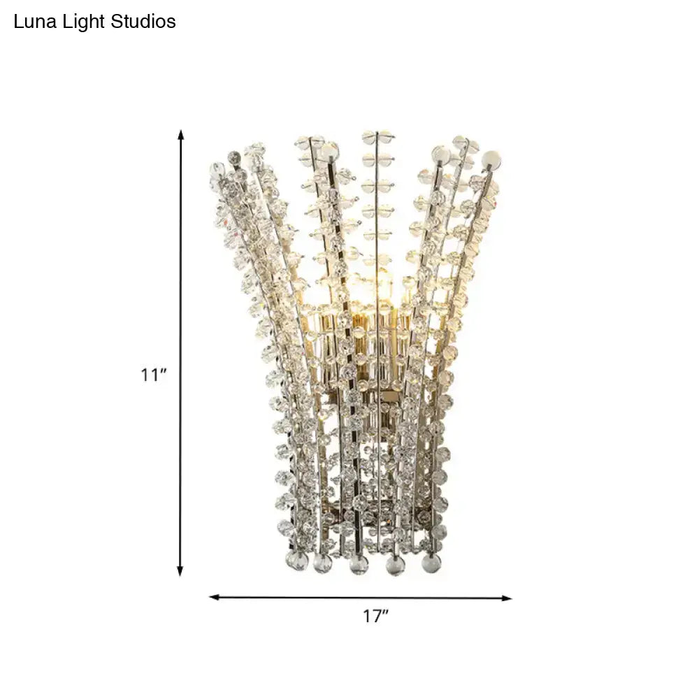 A modern silver crystal bead wall lamp with a chrome finish and cascading faceted crystal strands for bedroom use