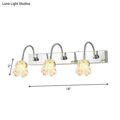 Modern silver crystal petal gooseneck arm vanity light with chrome finish and three textured glass lampshades emitting warm yellow light