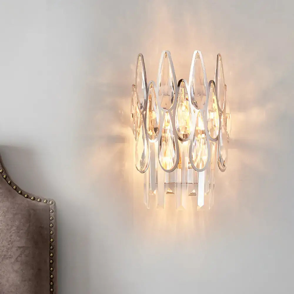 Modern silver crystal wall sconce with circular clear teardrop crystals and polished chrome frame for living room lighting