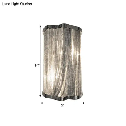 Modern silver finish tassel wall mounted light with cascading metal chains and blackened chrome accents for living room