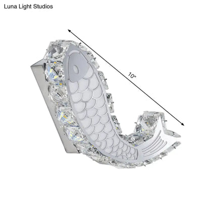 Modern silver fish wall sconce with crystal block shade, polished chrome base, and intricate scale detailing for bedroom light