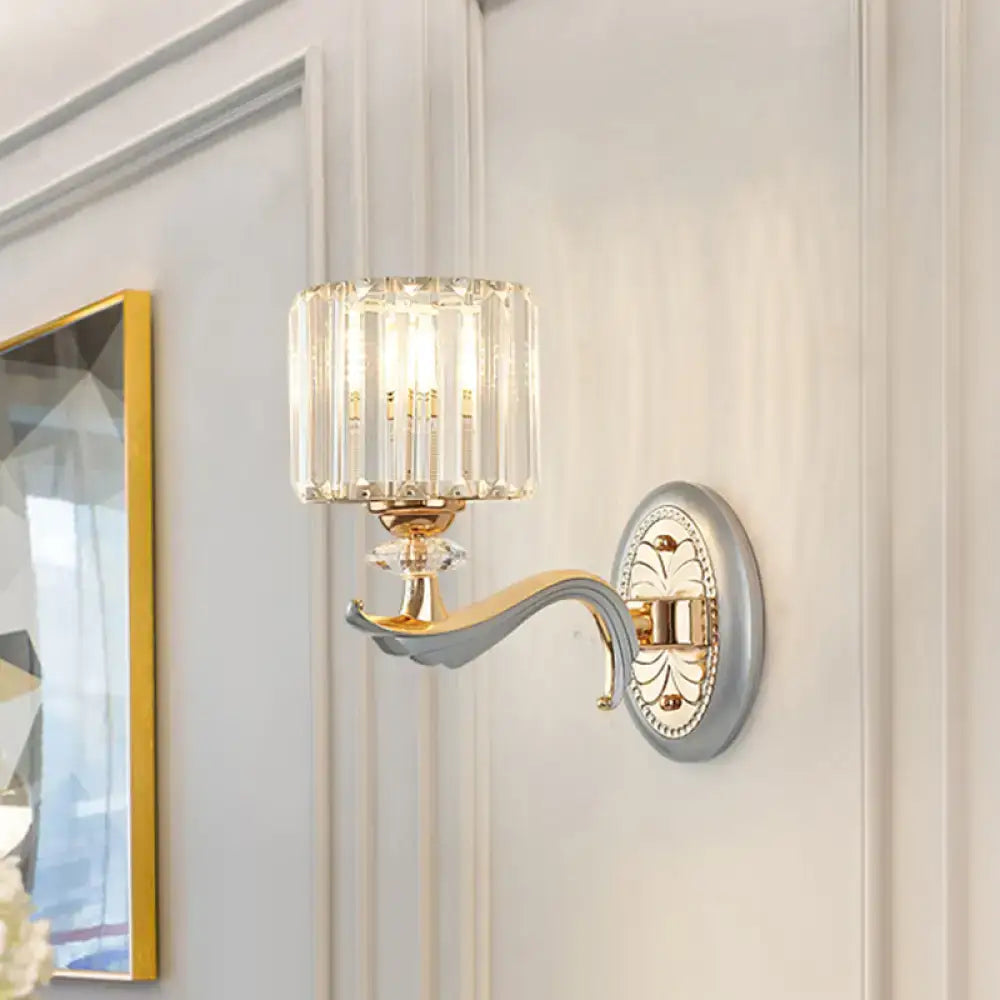 Elegant flush mount wall light with gold-toned metal arm, clear crystal shade, and vertical faceted glass panels refracting light