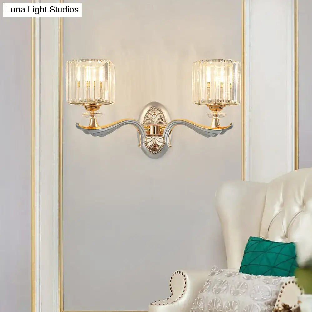 Elegant gold-toned flush mount wall light with ornate curved arms and clear crystal shade featuring bulb base design