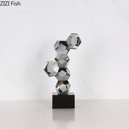 A sleek modern silver geometric crystal ball desk ornament sculpture with interconnected faceted spheres on black base