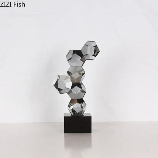 A sleek modern silver geometric crystal ball desk ornament sculpture with interconnected faceted spheres on black base