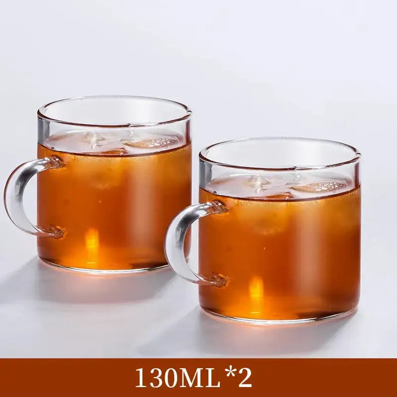 Clear glass handle coffee cups with sturdy silver handles filled with iced amber beverage in a coffee cup set