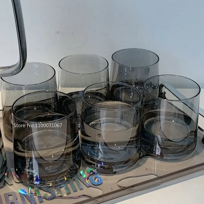 Set of six dark gray transparent glass tumblers with a modern minimalist design for use with a glass water pitcher