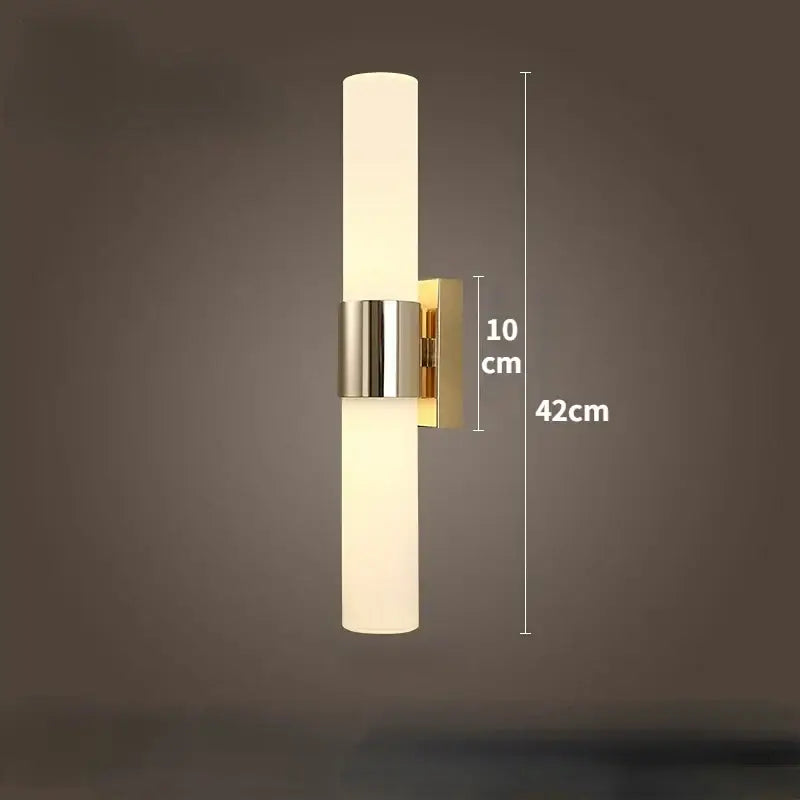 Modern gold-toned wall lamp with frosted glass cylinder and polished metal accents for decorbites led wall bedroom sconce