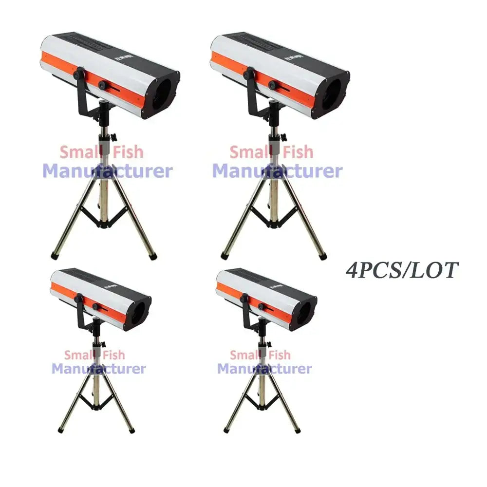 Four modern silver metal 300w led follow spot lights with white and orange body on black tripod stands for stage lighting