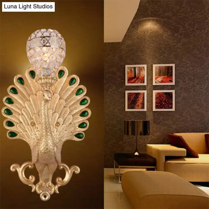 Modern silver peacock wall light with green gemstone accents and crystal globe, perfect as a bedroom sconce wall light