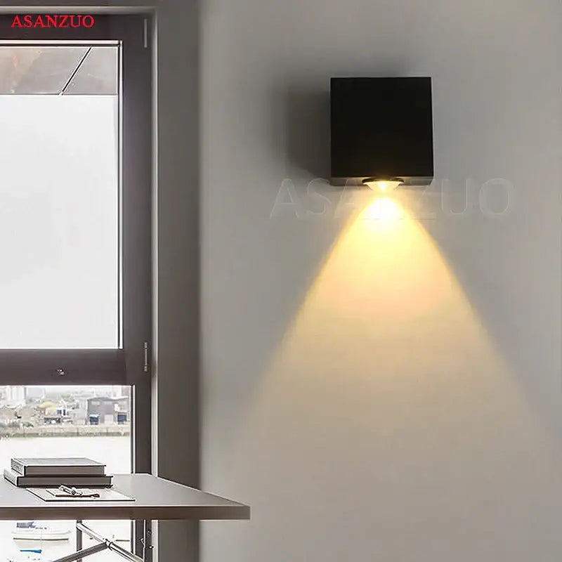 Modern silver square wall lamp with black led square wall fixture emitting a warm focused beam for living room use