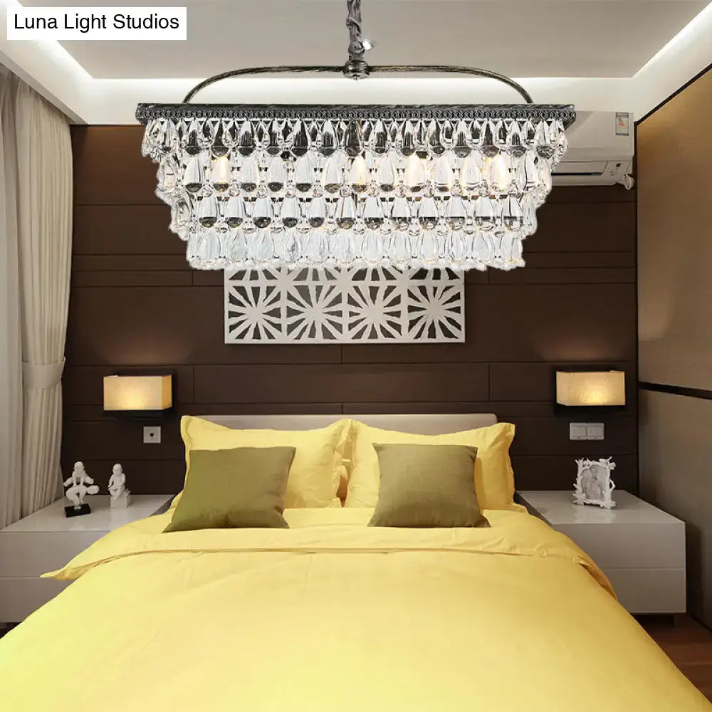 A sleek modern silver teardrop crystal ceiling light with dark metal frame for living room 220v-240v above bed