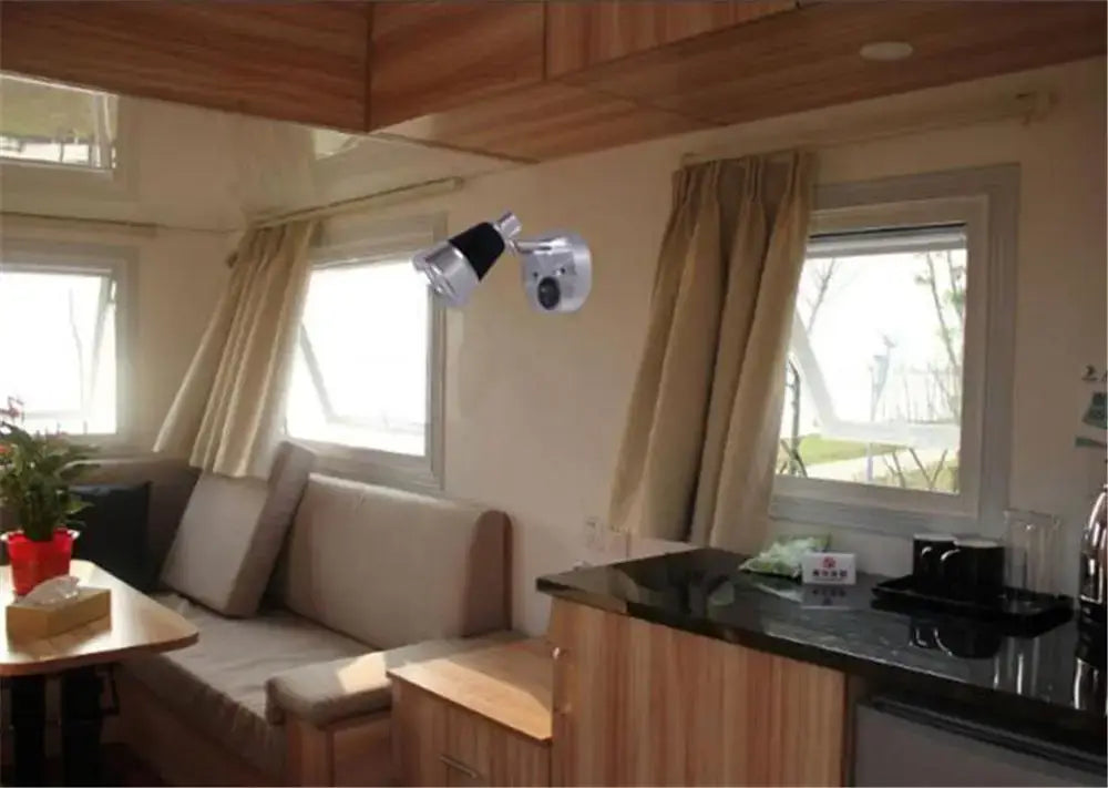 A sleek silver wall-mounted security camera with black lens and adjustable head ideal for white boat interior lights
