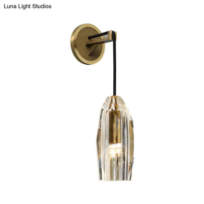 Modern single light brass wall sconce with clear crystal faceted shade and brass accents for bedroom lighting