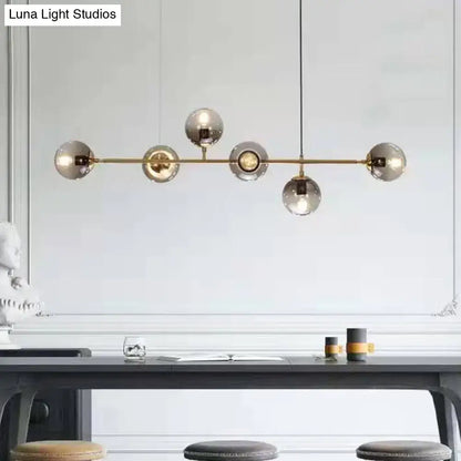 Modern brass bar pendant light with five smoked glass globe bulbs in smoke gray linear design for dining room