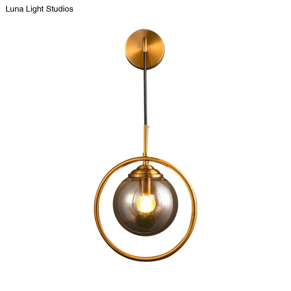 Gold-toned modern wall sconce with smoke gray clear glass globe and exposed bulb for bedroom 220v-240v 110v-120v use