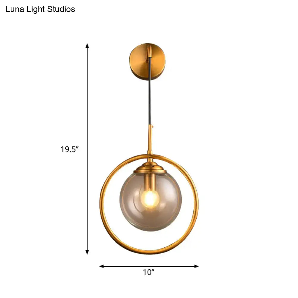 Modern smoke gray clear glass globe sconce bedroom wall light with gold-toned spherical pendant and smoked glass globe