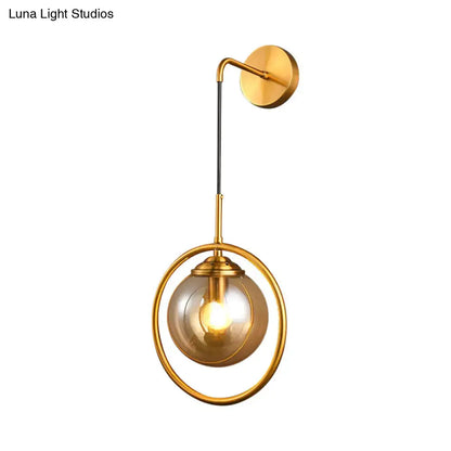 Modern smoke gray clear glass globe sconce with gold-toned circular frame and amber glass globe for bedroom wall lighting in 220v-240v 110v-120v