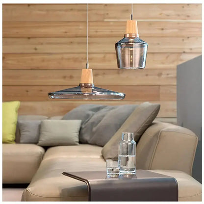 Modern smoked glass and wood pendant light with clear glass shades and wooden accents above a cozy living room