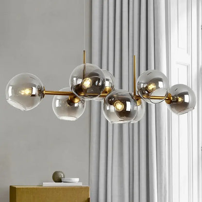 Modern brass-finished pendant lights with clear glass spheres and warm bulbs for dining room decorbites glass ball pendant