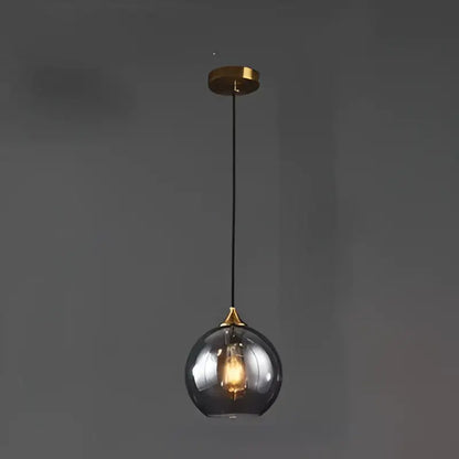 A sleek modern smoked glass ball pendant light with warm glow and brass accents ideal for kitchen and dining room decorbites glass ball pendant lights